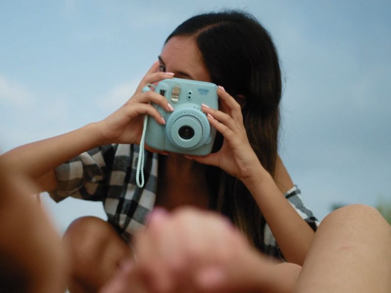 Devojka fotografiše sa Instant kamerom
