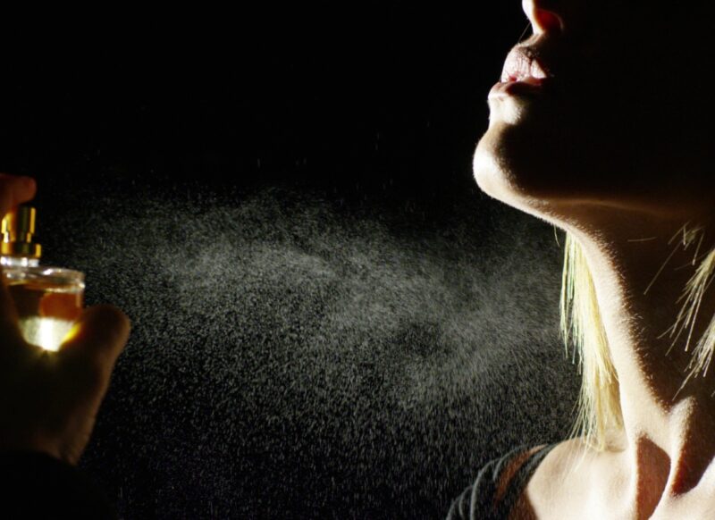 prikaz devojke koja nanosi parfem na svoj vrat