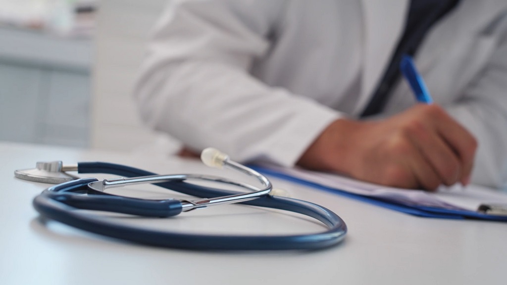 Doktor na papiru piše o procesu lečenja hemoroida kod pacijenta
