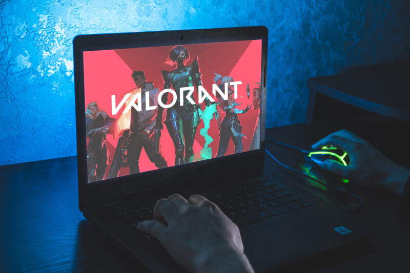 Igrač koristi laptop i gaming miš dok je na ekranu pokrenut Valorant