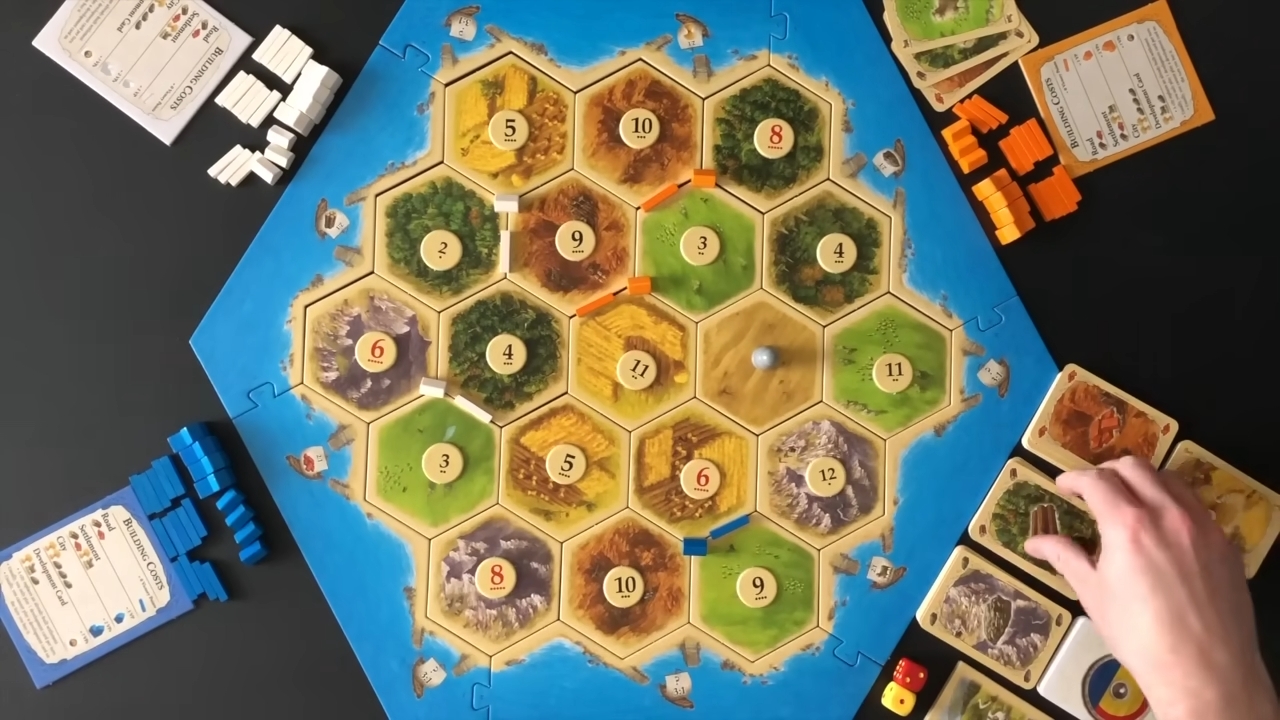 Tabla za Catan sa resursima, putevima i figuricama igrača.